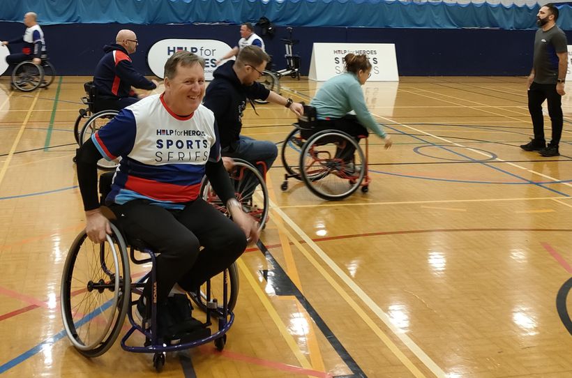 An official from British Wheelchair Basketball teaches some veterans some skills on the court. - Credit: Help for Heroes. Veterans enjoy a game of wheelchair basketball.