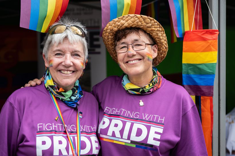 jean and jo in pride rainbows at a campaign