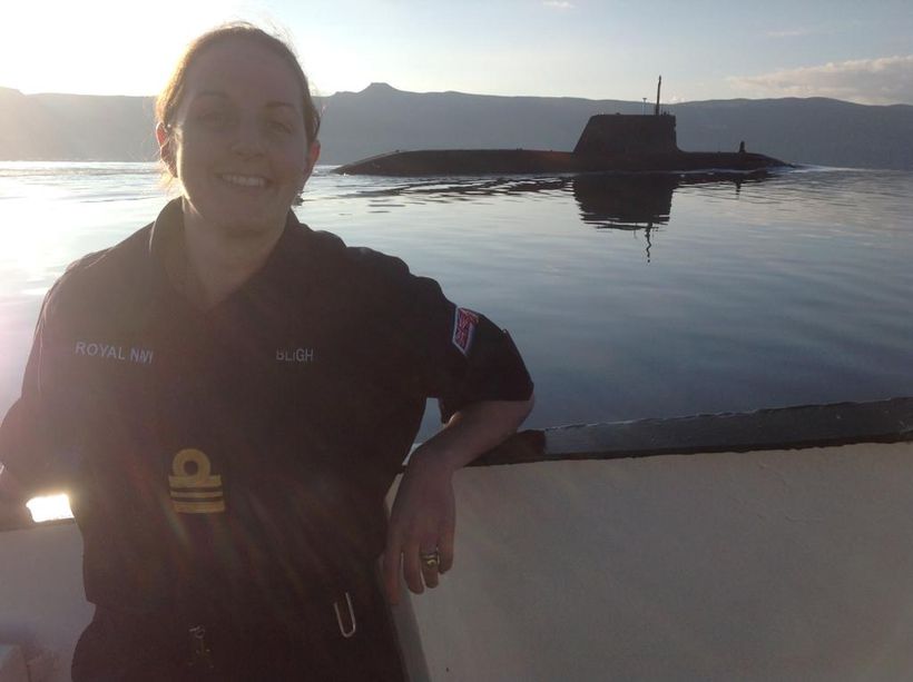 Sarah Hattle stands in front of a submarine smiling